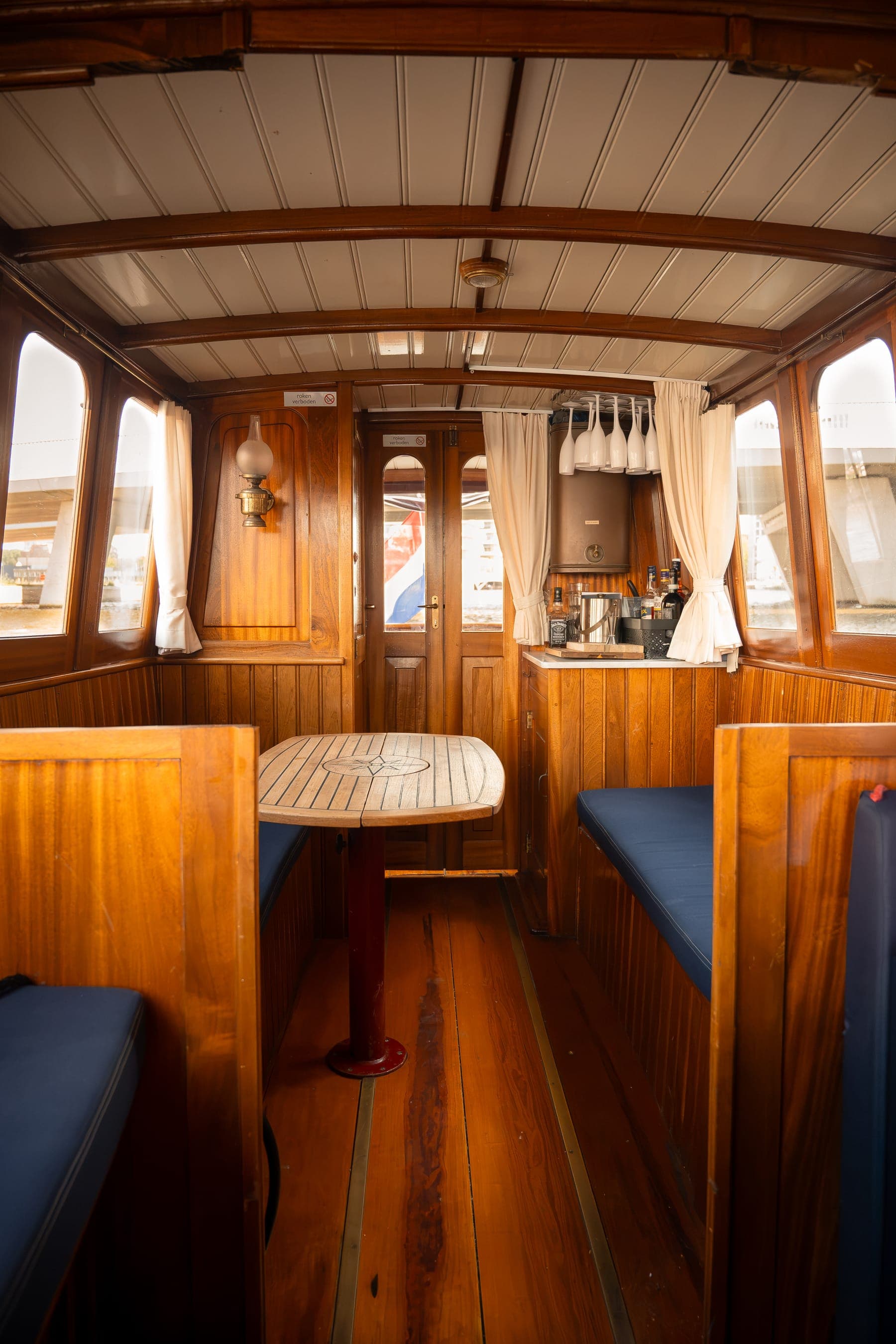 The classic saloon of the Dauphine with teak deck, varnished woodwork and navy blue cushions